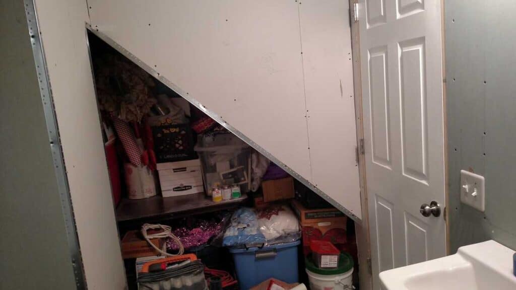 Downstairs Bathroom Part 3 http://www.b4andafters.com triangle opening of closet under stairs