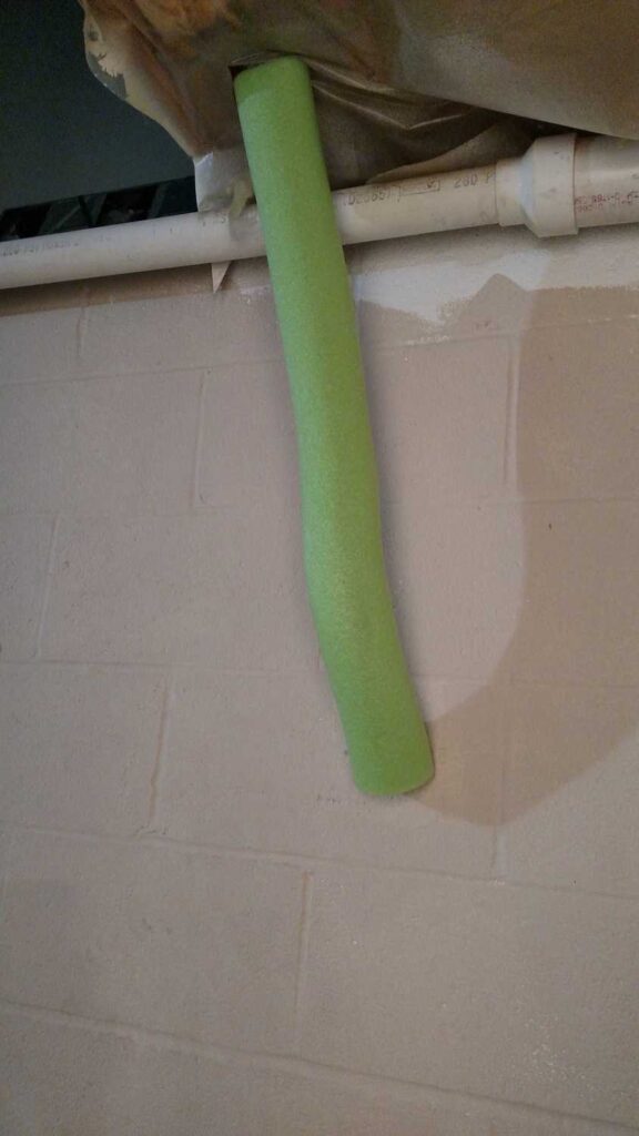 pipe covered with a green pool noodle