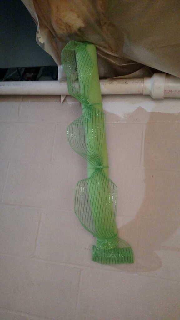 pool noodle covered pipe, covered with green sparkly deco mesh