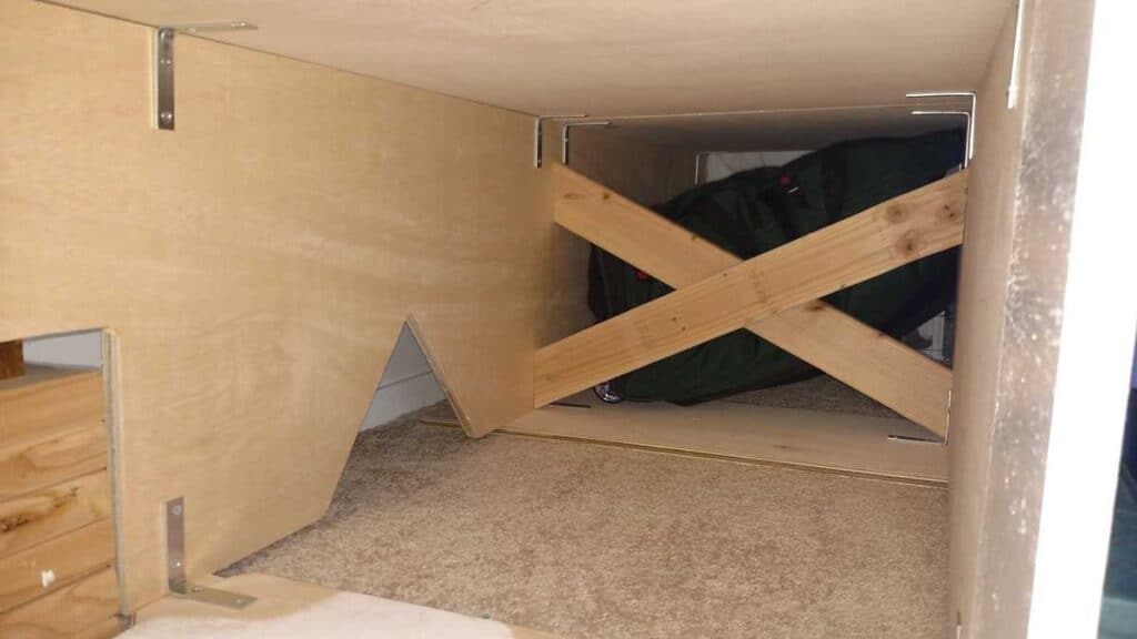 underneath storage bed, with access holes to electrical outlets