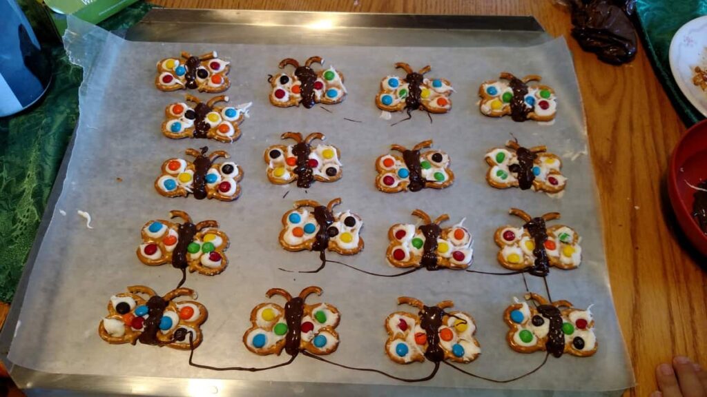 Butterfly chocolate covered pretzels in rows drying on wax paper