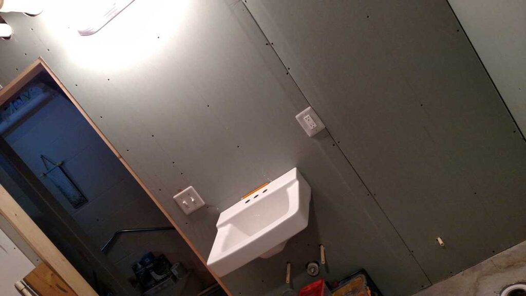 Downstairs Bathroom Part 3 https://www.b4andafters.com green drywall covering sink bathroom wall