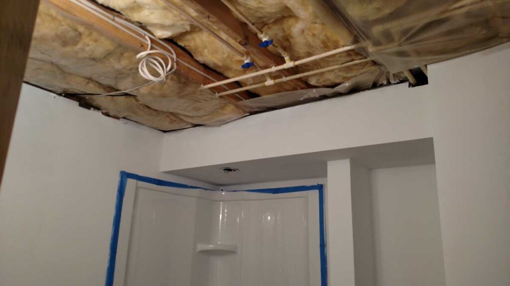 Downstairs Bathroom Part 3 https://www.b4andafters.com exposed ceiling showing water pipes and insulation