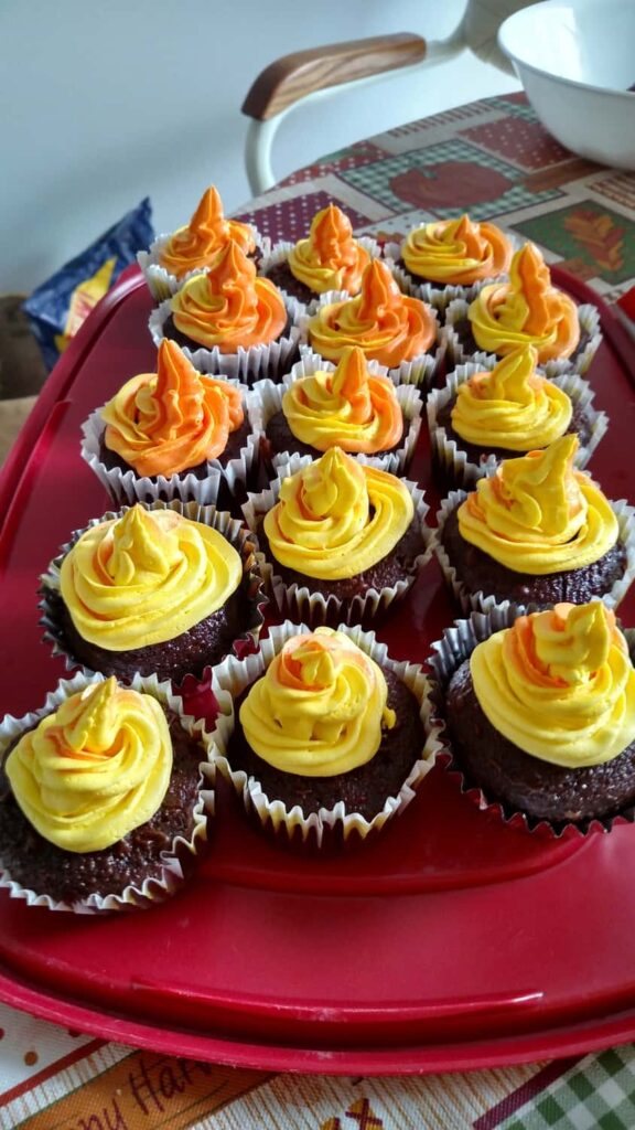 yellow and orange swirled frosting on cupcakes