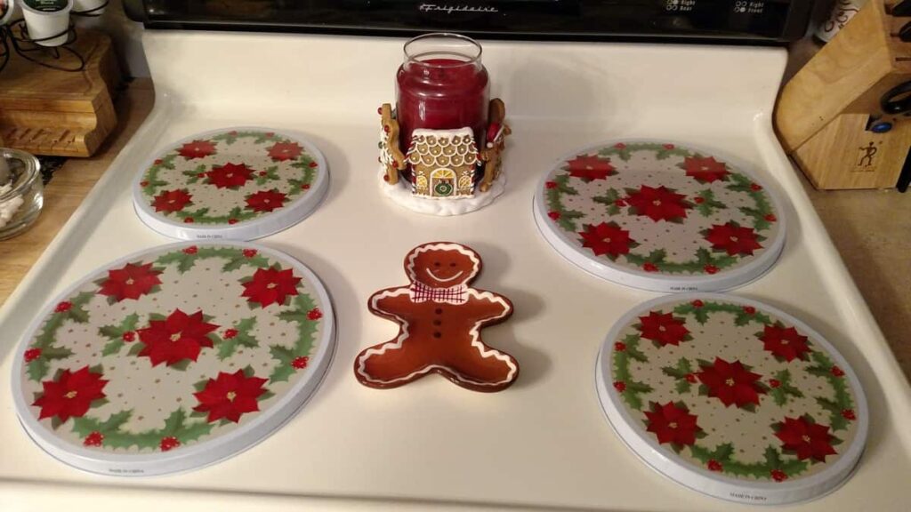 Christmas stovetop with poinsettia burner covers with gingerbread spoonrest and gingerbread candle holder