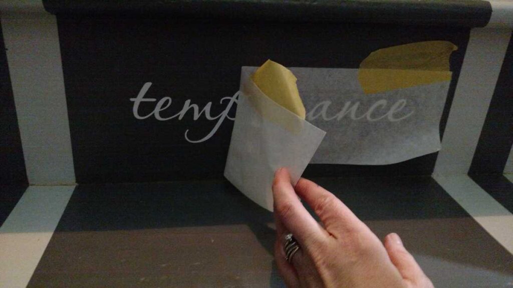 Adding Vinyl Stickers to the Basement Stairs https://www.b4andafters.com tearing off top layer of vinyl word sticker