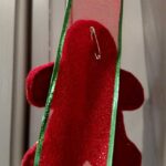 safety pin on back of felt gingerbread boy holding it to ribbon