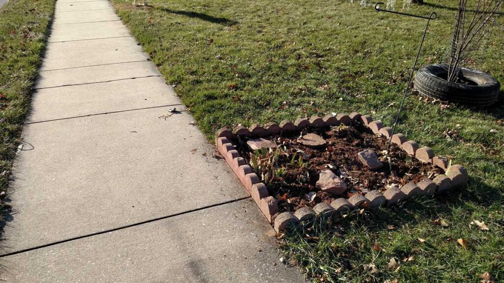 Scalloped Brick Edging http://www.b4andafters.com sidewalk view of flower bed