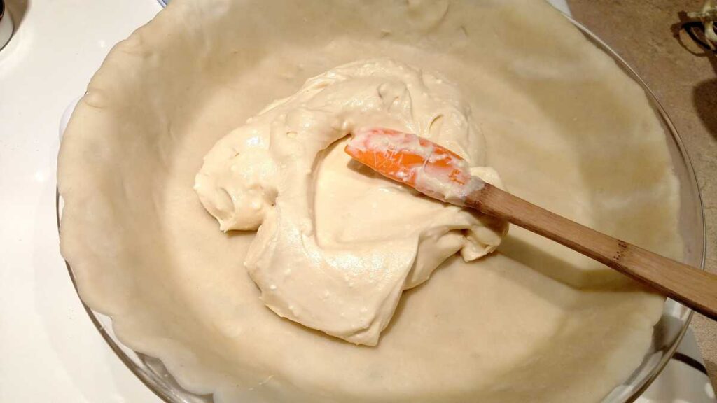 cream cheese with spatula in pie crust