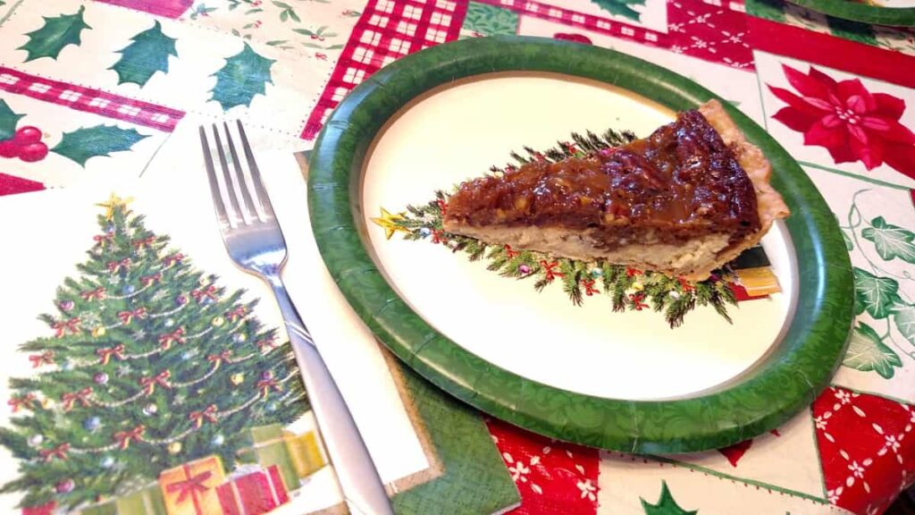 Christmas tree napkin and paper plate with pie lined up on the Christmas tree