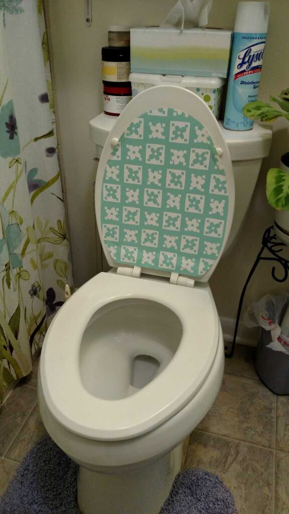 flowered contact paper on open toilet lid
