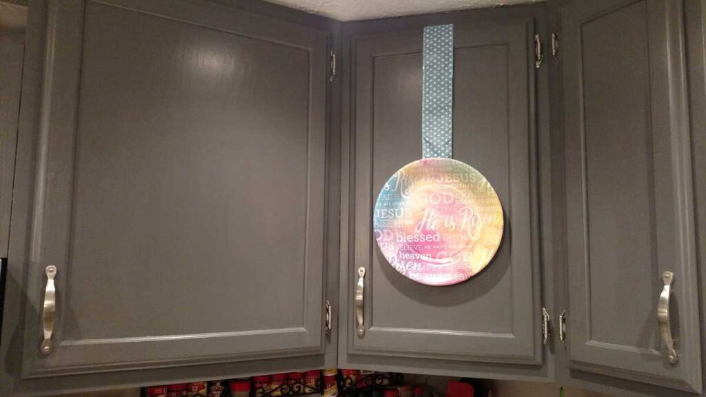 kitchen cabinet with paper plate hanging from ribbon