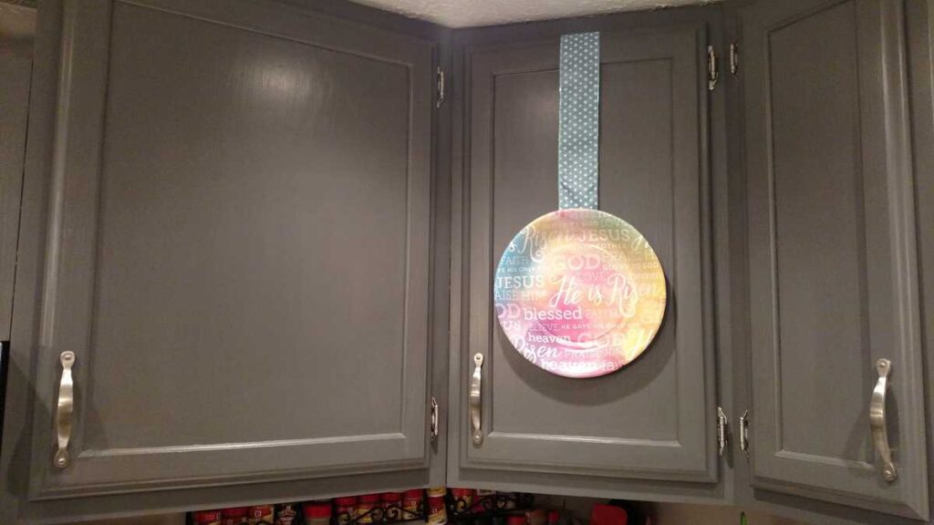 Easy Easter Kitchen Cabinet Decor https://www.b4andafters.com kitchen cabinet with paper plate hanging from ribbon