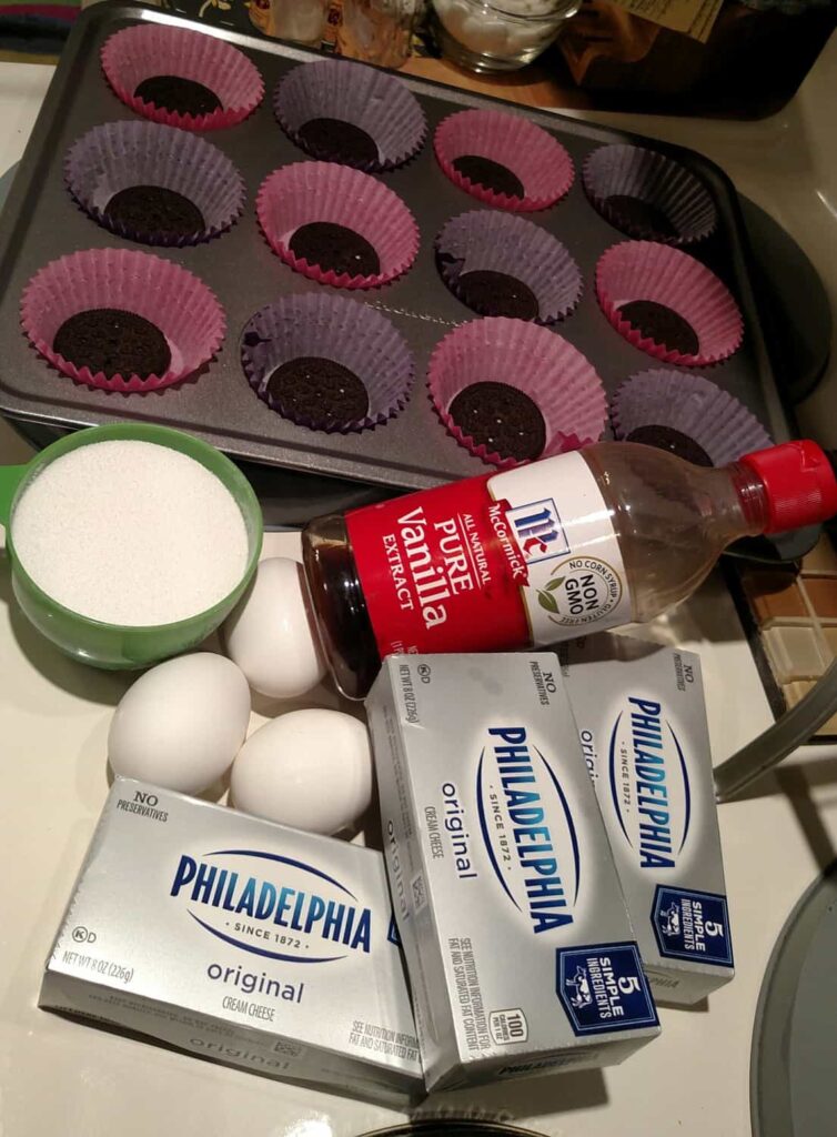 ingredients to make miniature cheesecakes: eggs, sugar, cream cheese, vanilla