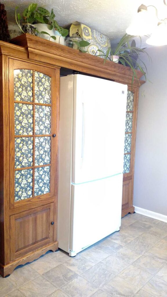 side view of the fridge with cabinets as pantries on each side