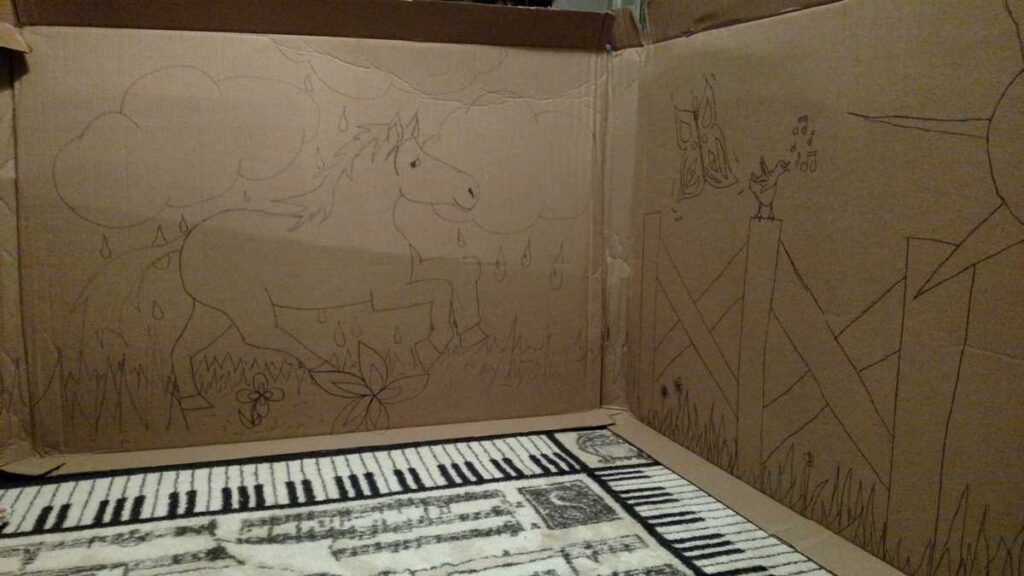 horse and fence outdoor scene drawn on a large piece of cardboard