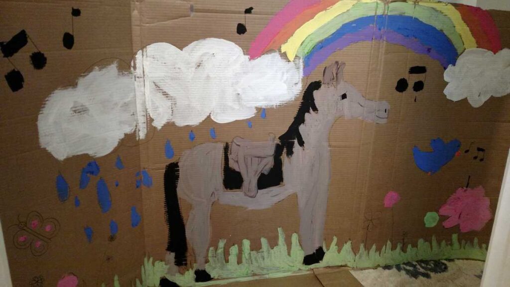 horse and rainbow scene all painted on a large cardboard piece