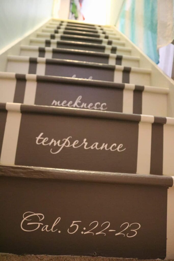 Adding Vinyl Stickers to the Basement Stairs https://www.b4andafters.com closeup of vinyl word stickers on stairs