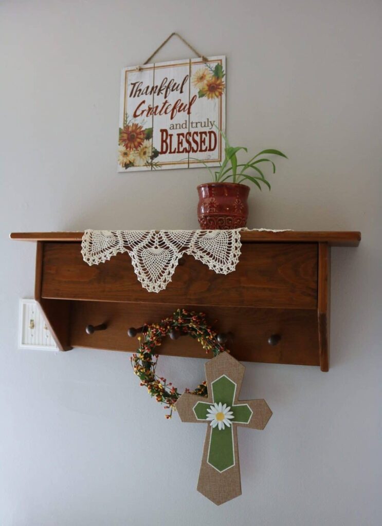 Thankful sign, plant on a wall shelf, cross on peg