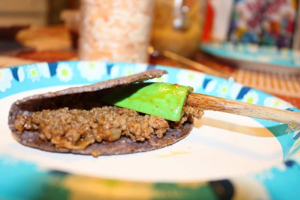 The Right Way to Fill a Taco https://www.b4andafters.com taco with meat on it and a spreader