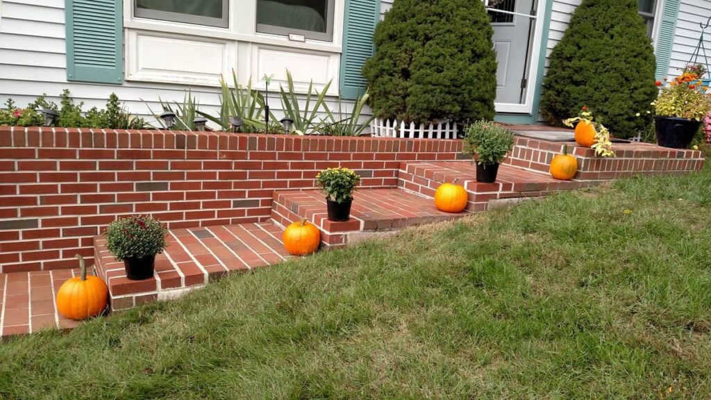 mums and pumpkins lining brick steps