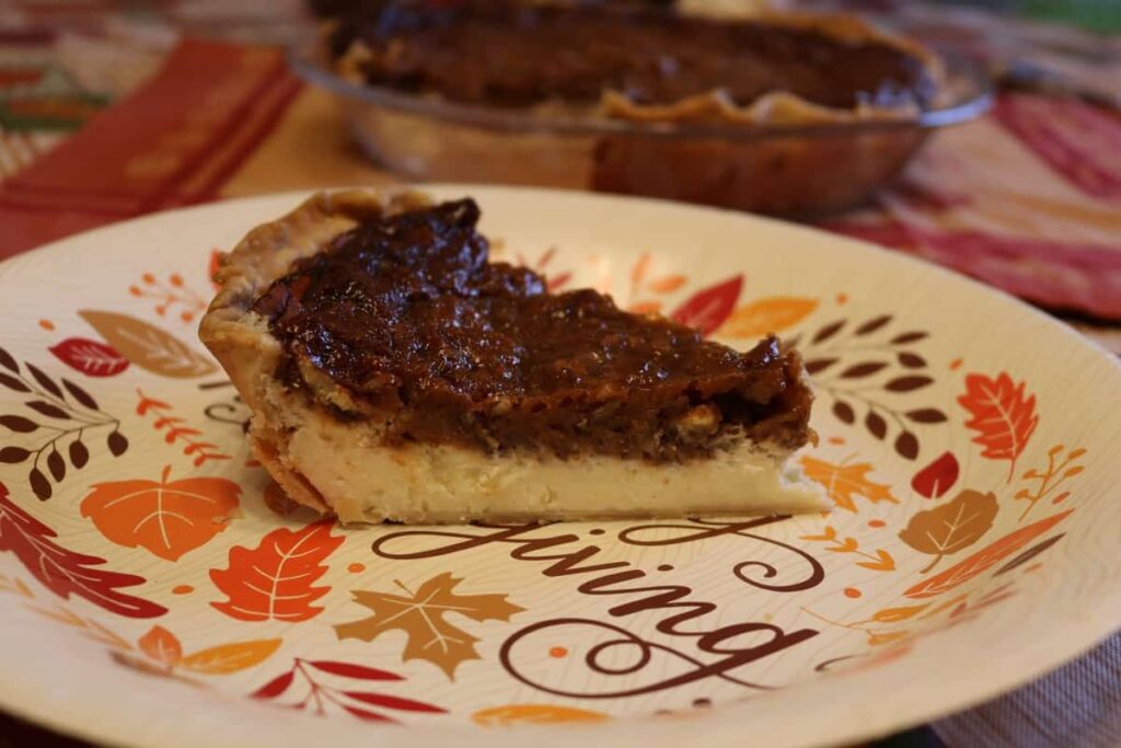 closeup of side view of piece of pecan cheesecake pie