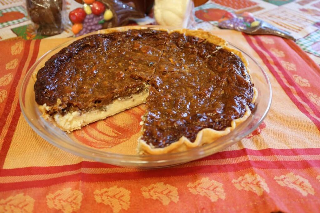 gorgeous pecan cheesecake pie with piece cut out of it