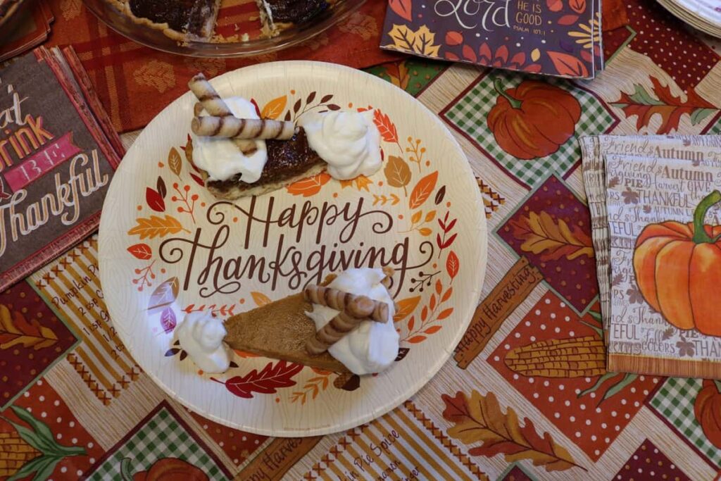 two pieces of pie on a paper plate that says Happy Thanksgiving