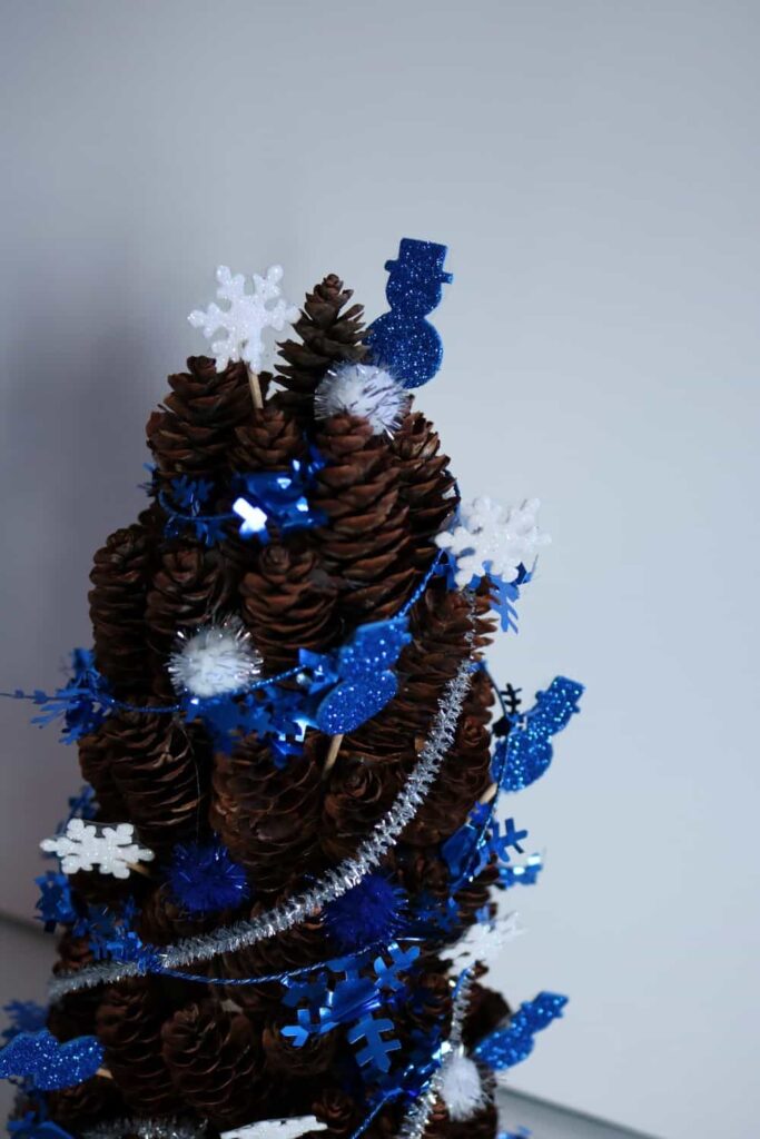 closeup of blue and white winter pine cone tree