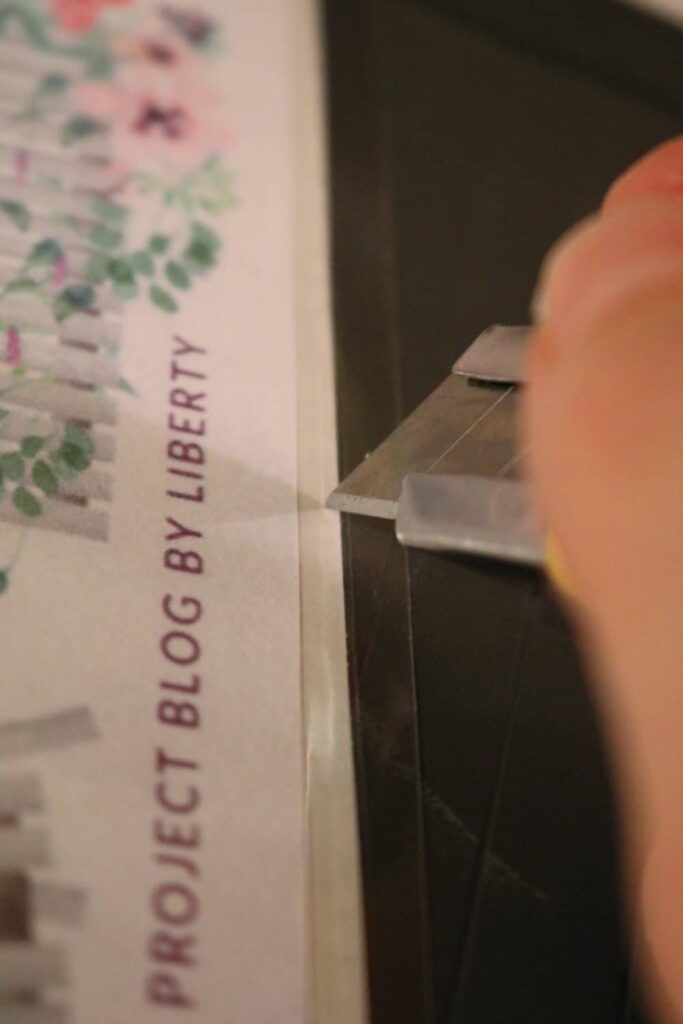 using an exacto or craft knife to cut the laminated sticker loose from its backing