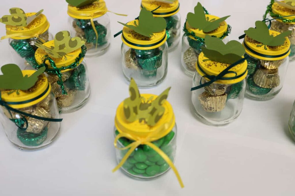 jars with butterflies on lids, ribbons, and candy in the jars https://www.b4andafters.com/Baby-Shower-Favors