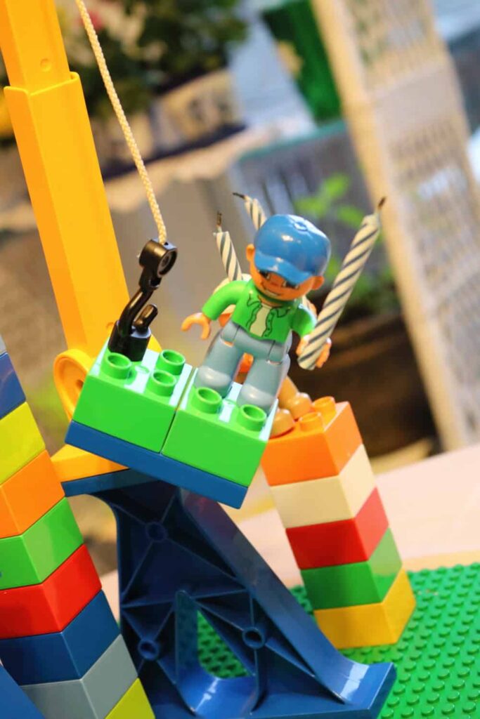 lego man hanging from a crain