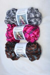 brown, pink, and black yarn, one skein of each color