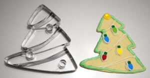 Large Christmas Tree cookie cutter next to an actual cookie made with the cutter