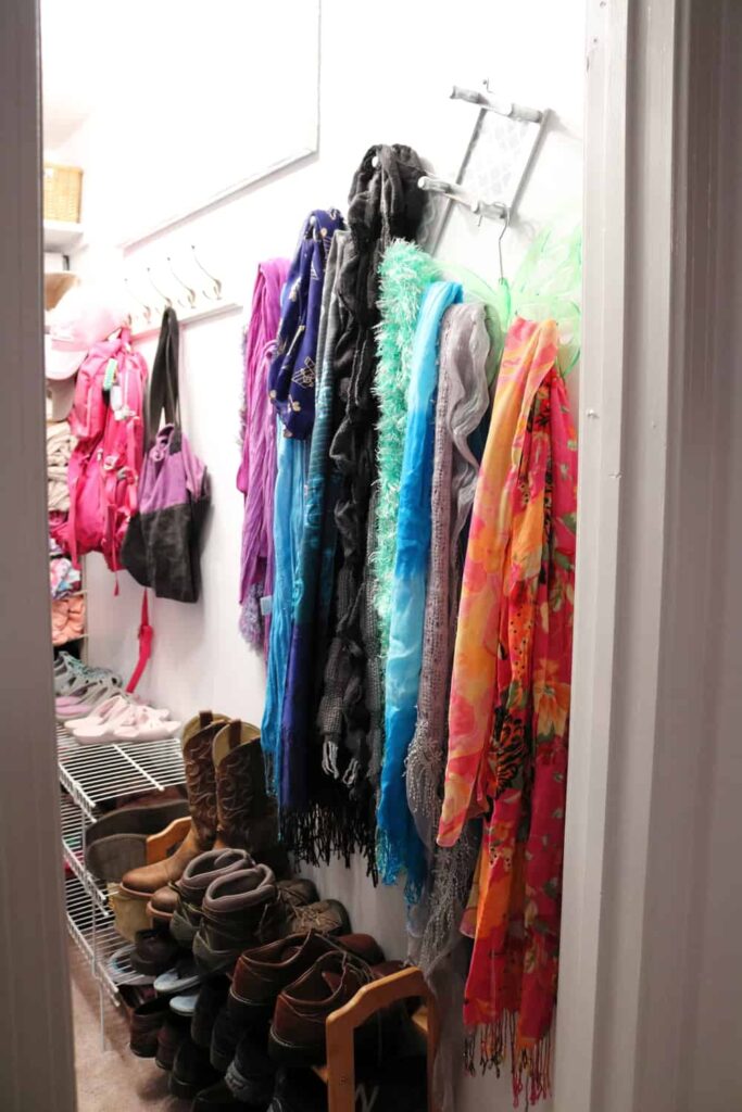 scarves on closet wall with shoes underneath