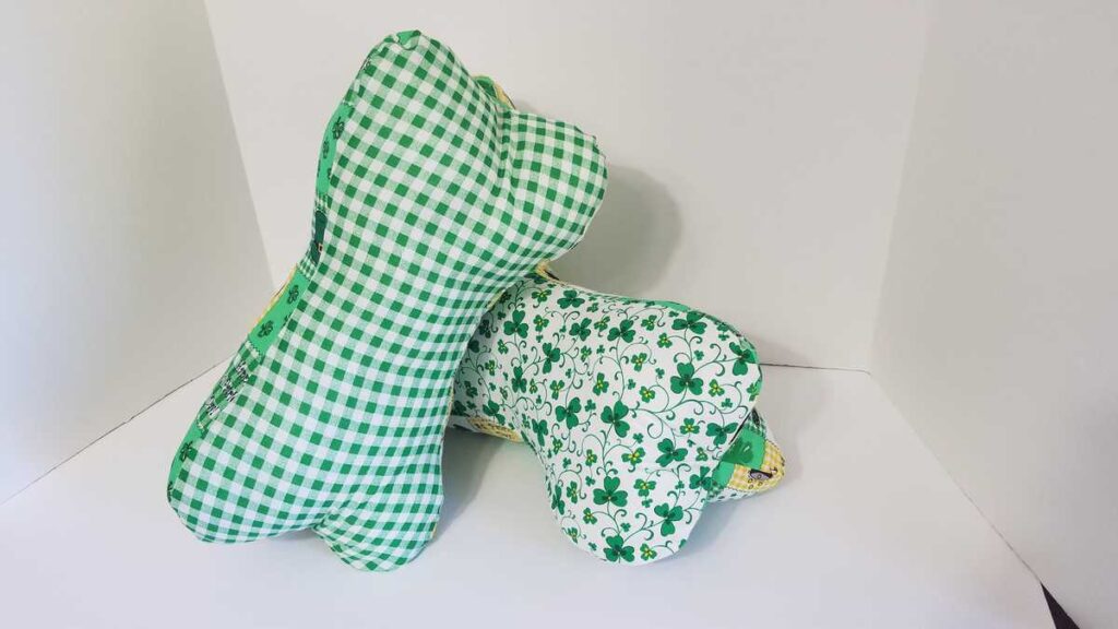 two green neck bone pillows stacked on each other