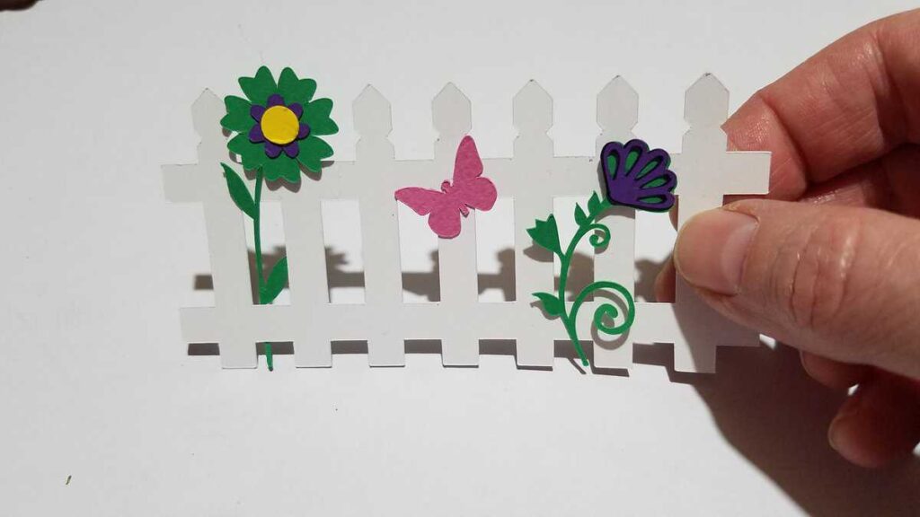 paper picket fence with paper flowers and butterfly