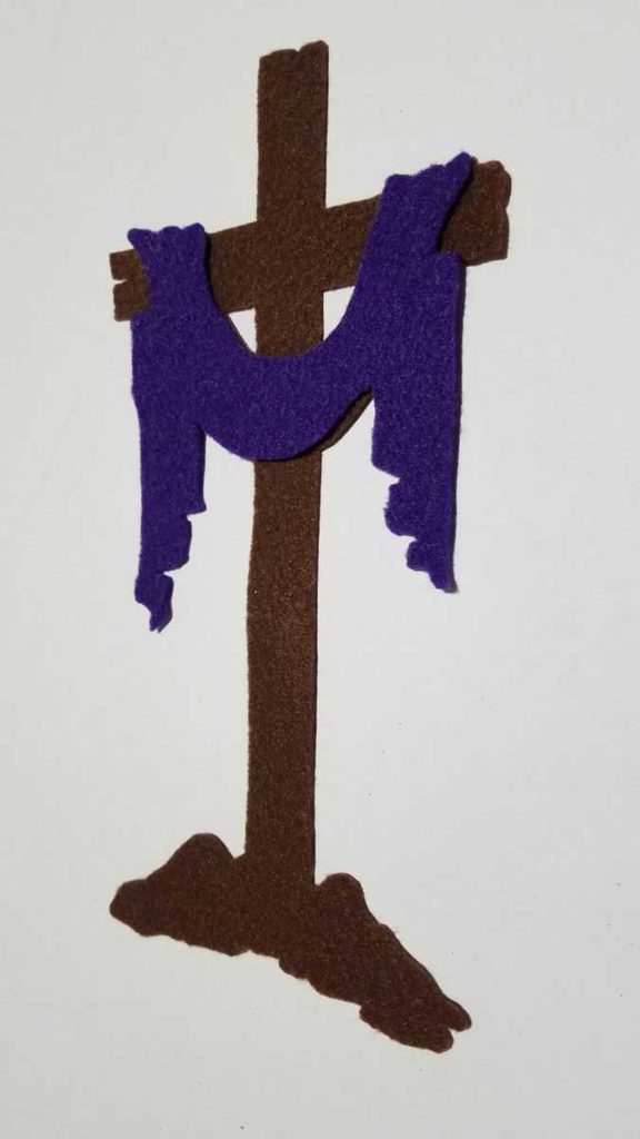 felt cross with purple cloth draped over it