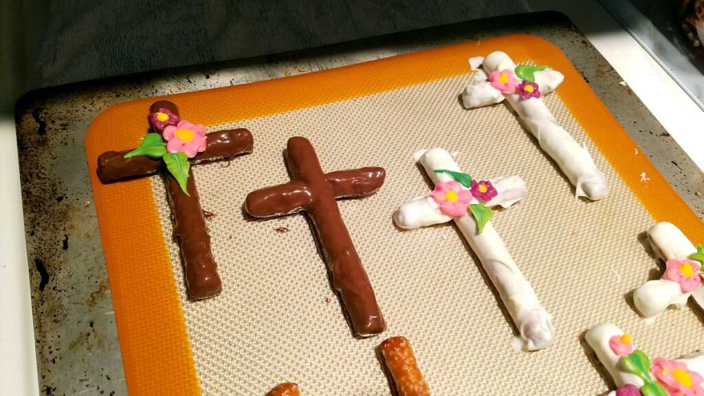 dark chocolate cross pretzel with flowers being assembled
