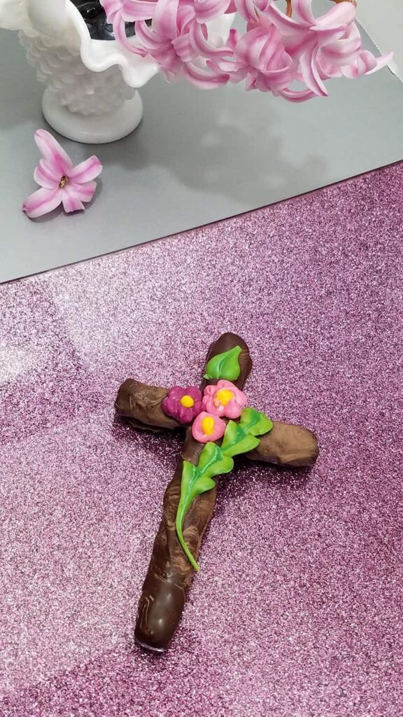 dark chocolate covered cross pretzel with flowers and leaves