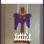 Easter Felt Cross with purple robe draped, on a kitchen cupboard door