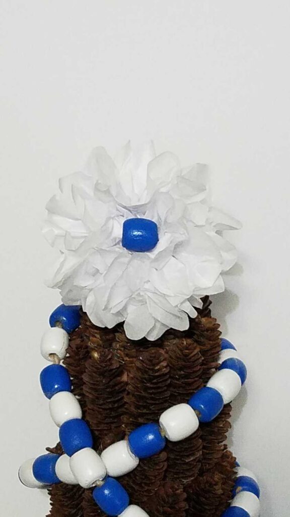 white tissue paper flower with blue bead center