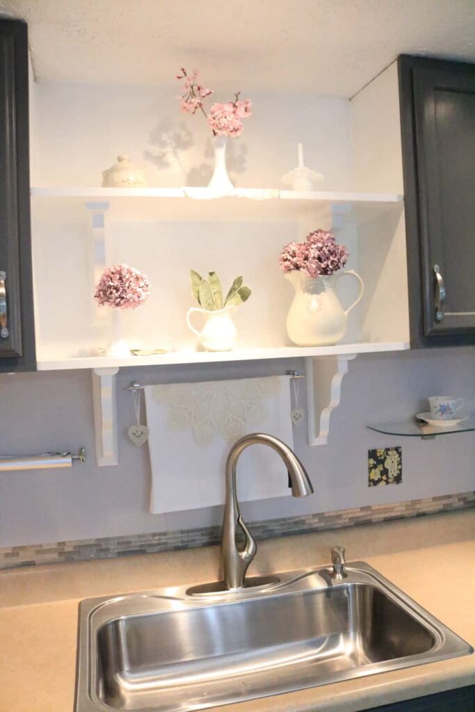 pink flowers on shelves with faucet