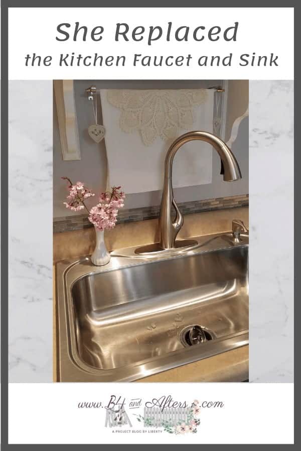 pull down kitchen faucet with pink flowers in a vase beside it