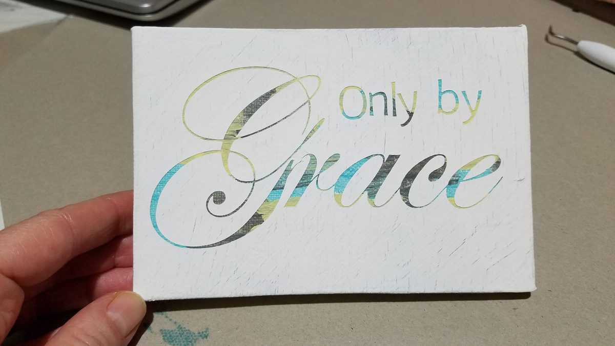 reverse stencil painting that says Only by Grace
