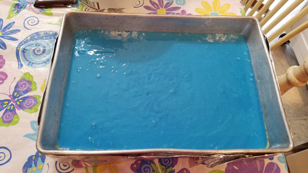 bright blue cake batter in 9 x 13 cake pan