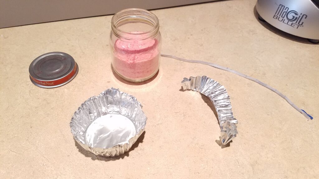 foil cupcake liner beside a small jar with pink powder in it