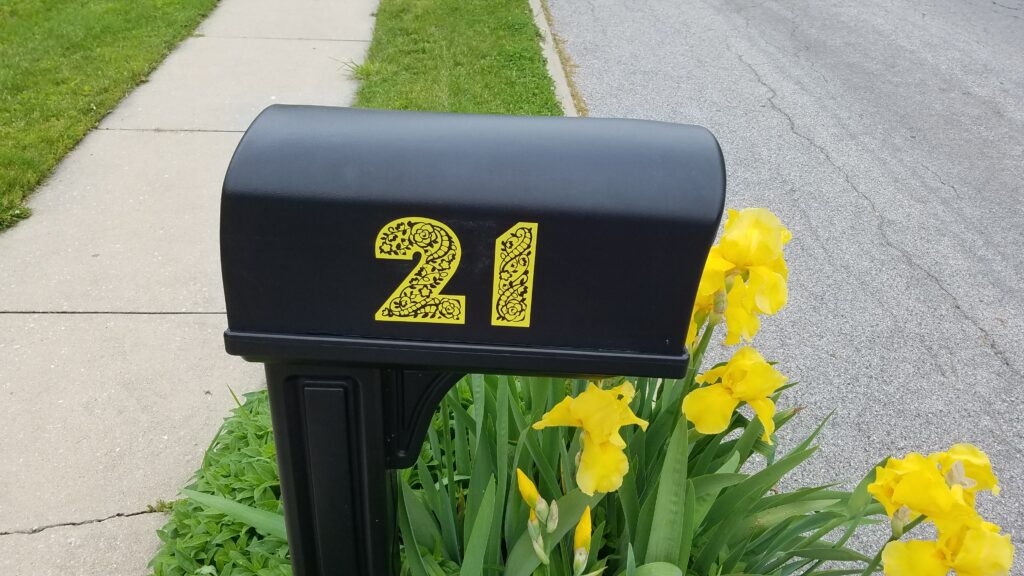 black mailbox with yellow numbers 21 on side