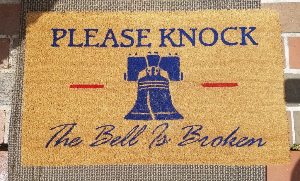 foot doormat that has a picture of the Liberty Bell and the words "Please Knock The Bell is Broken"