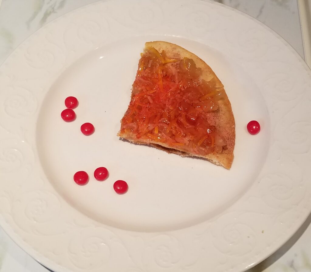 one slice apple grande with red hots on a white plate